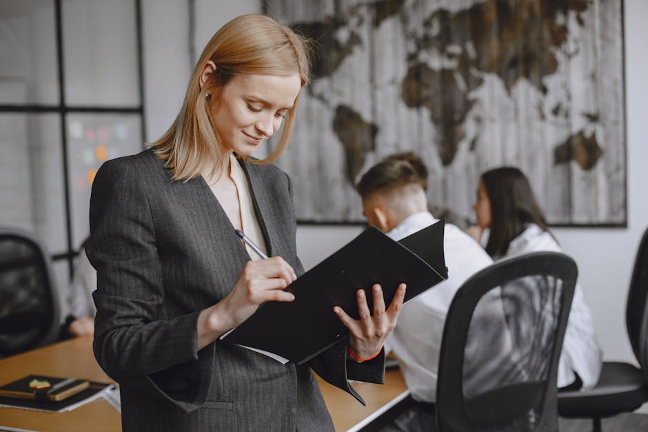 Confident businesswoman in formalwear taking notes during a team meeting in a modern office