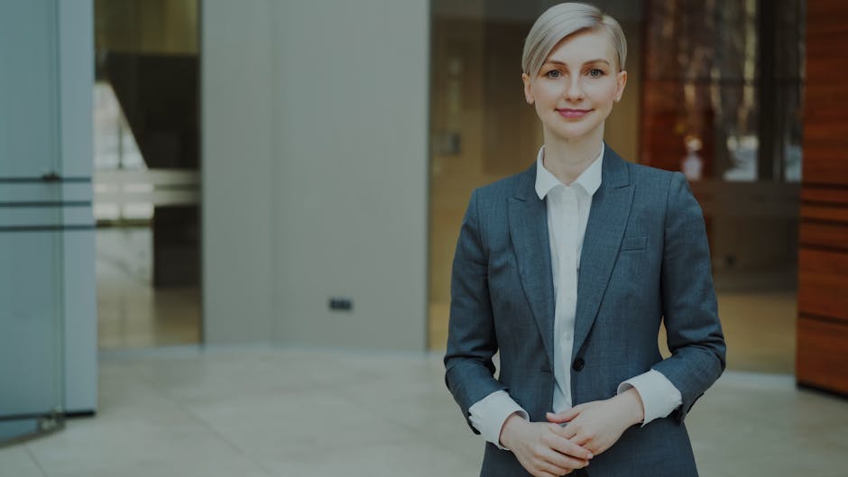 Confident businesswoman in a suit standing indoors in an elegant office setting