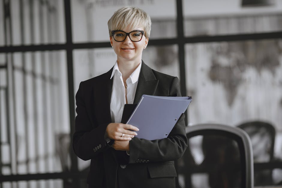 Professional woman in a suit holding a folder in a modern office setting